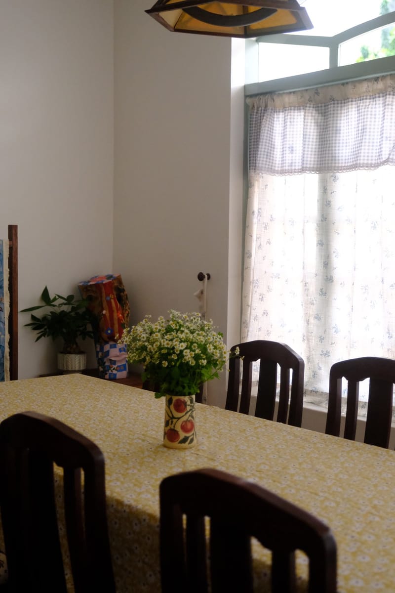 Hoa trên bàn ăn cạnh cửa sổ