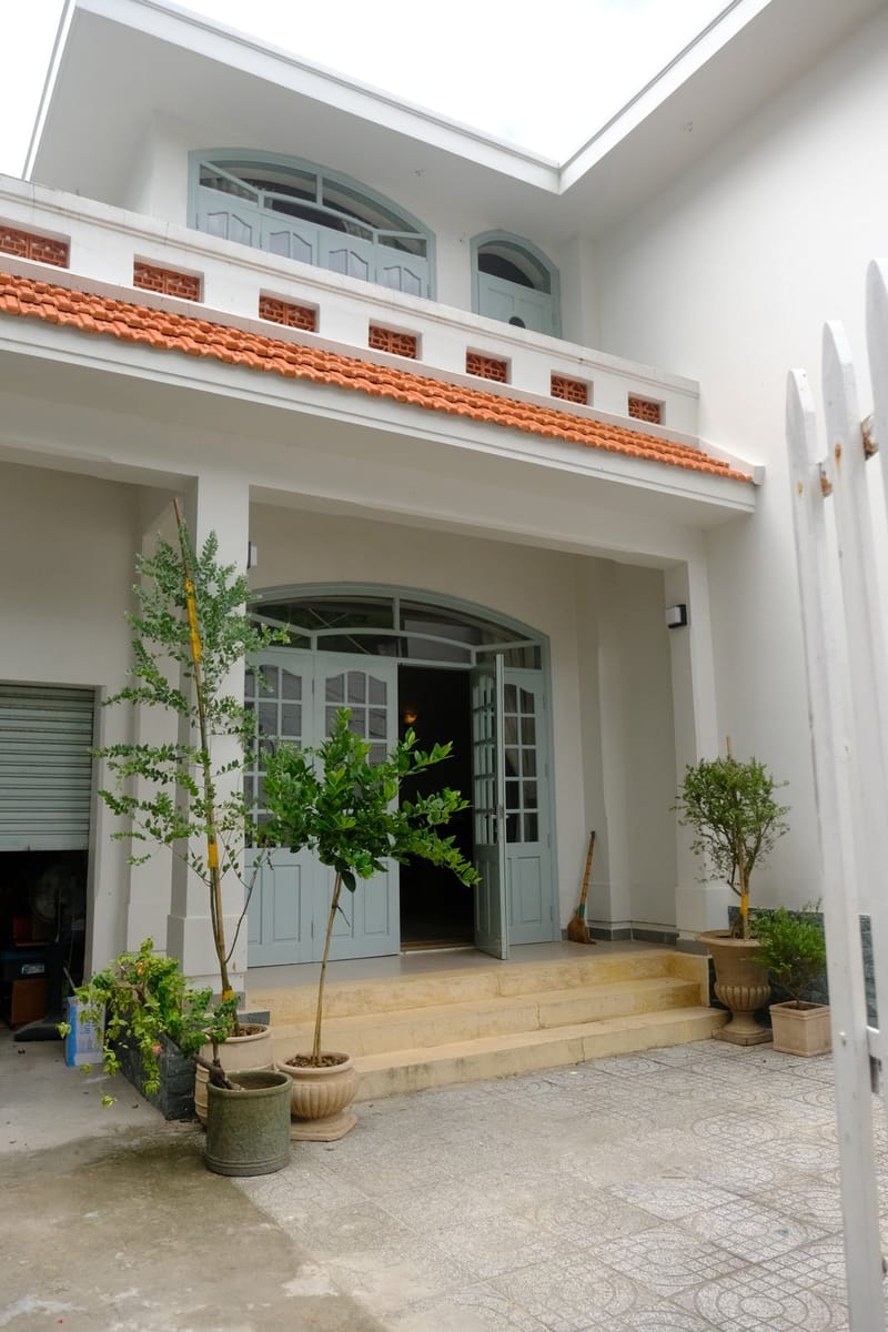 Mặt tiền màu nhạt và lối vào vòm của BRIO House