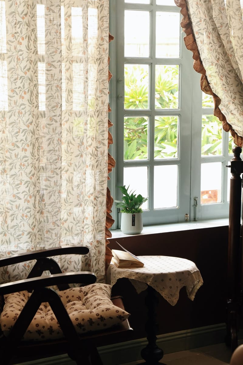 Ghế gỗ và bàn nhỏ bên ô cửa sổ đầy nắng ở BRIO House