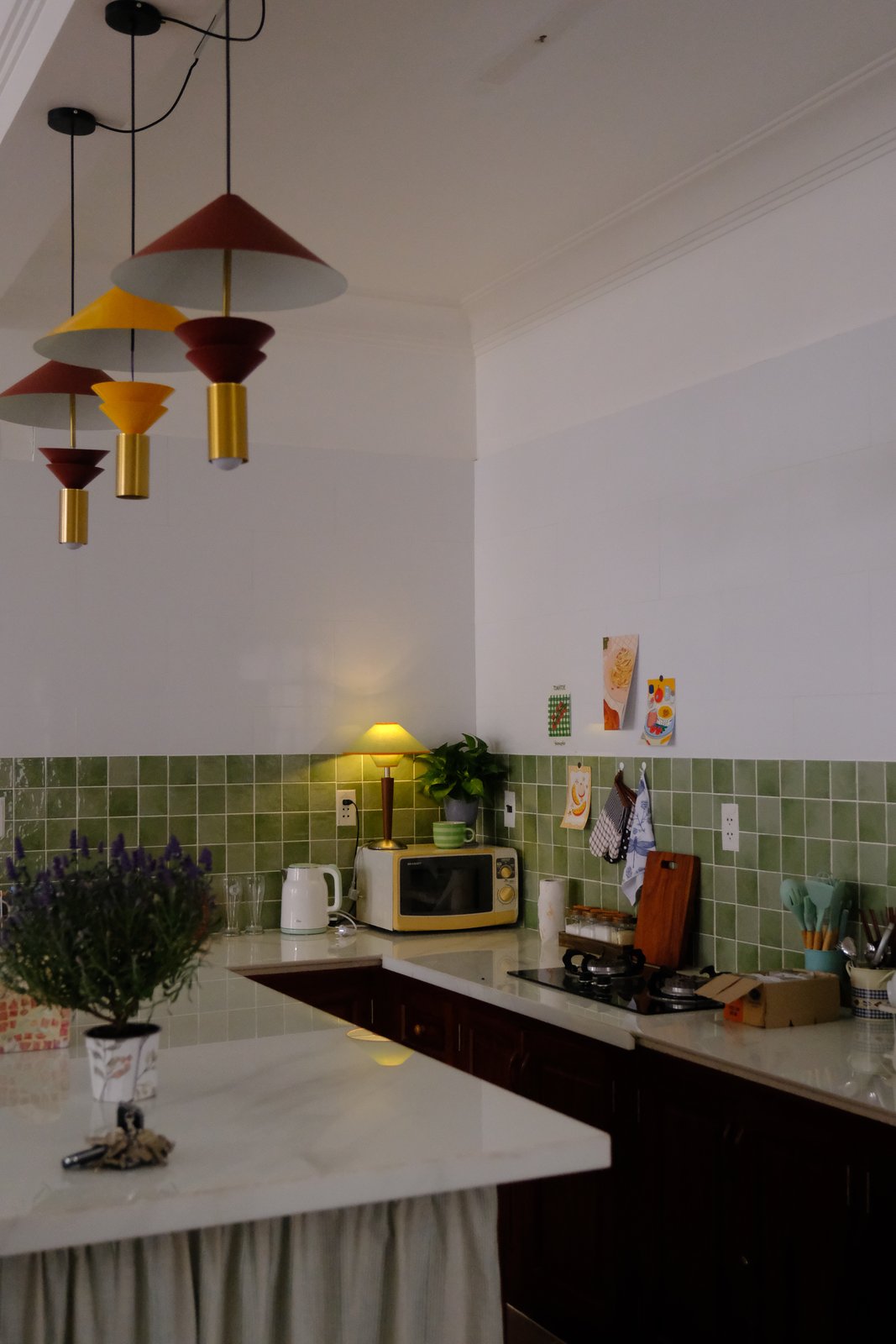 Gian bếp lát gạch xanh và đèn thả nhiều màu ở BRIO House
