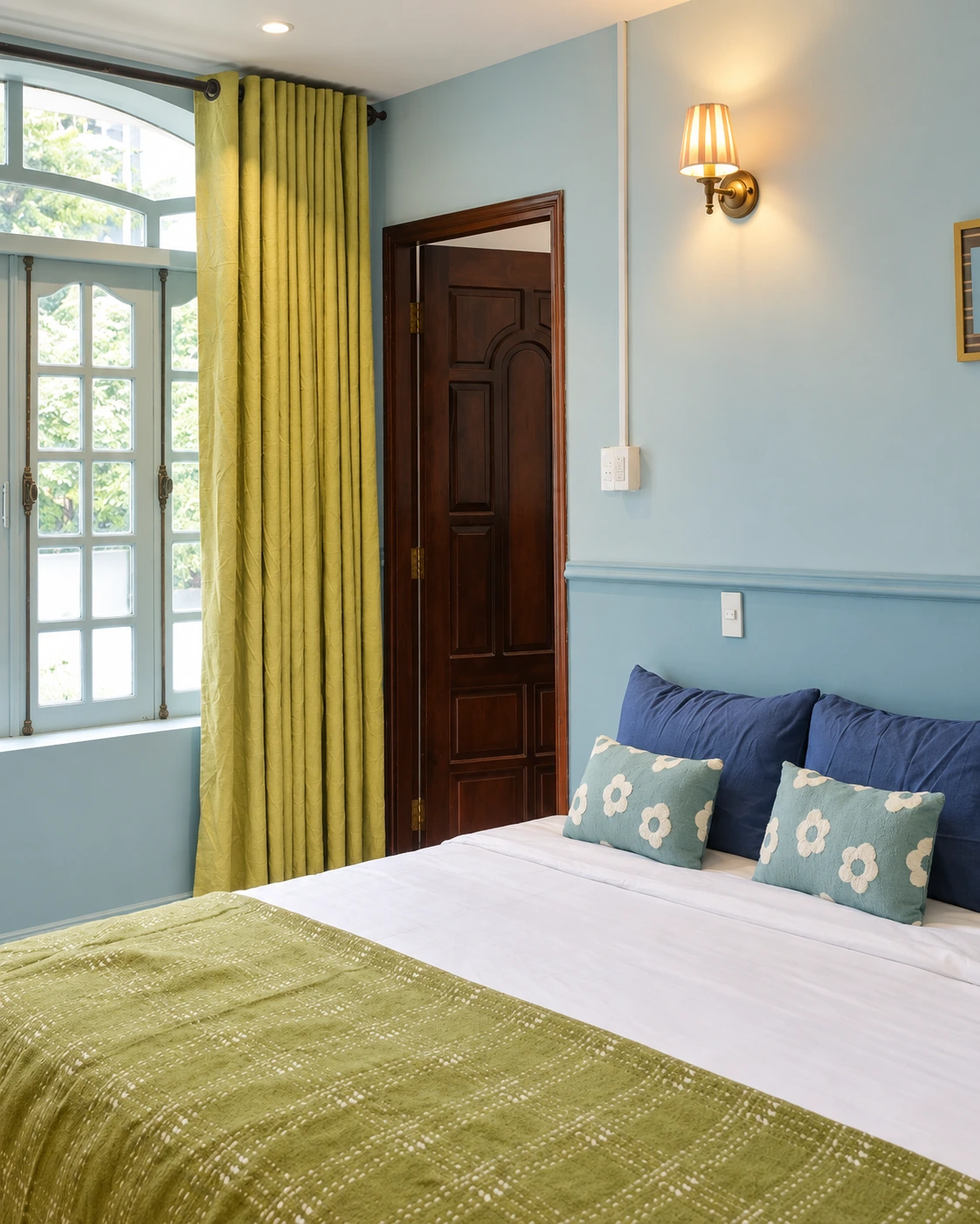 Giường MARE bên cửa sổ vòm và rèm xanh lá