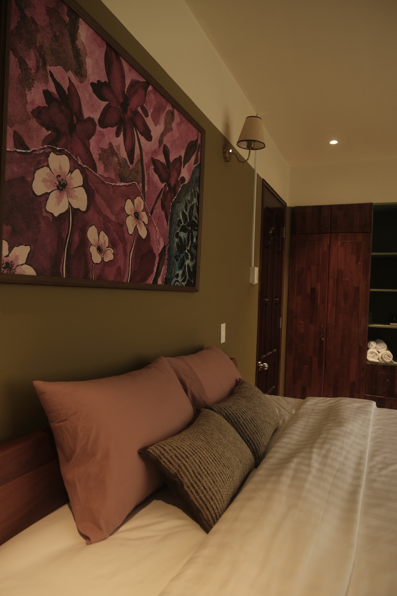 SERA's floral artwork, coral pillows and wooden wardrobe
