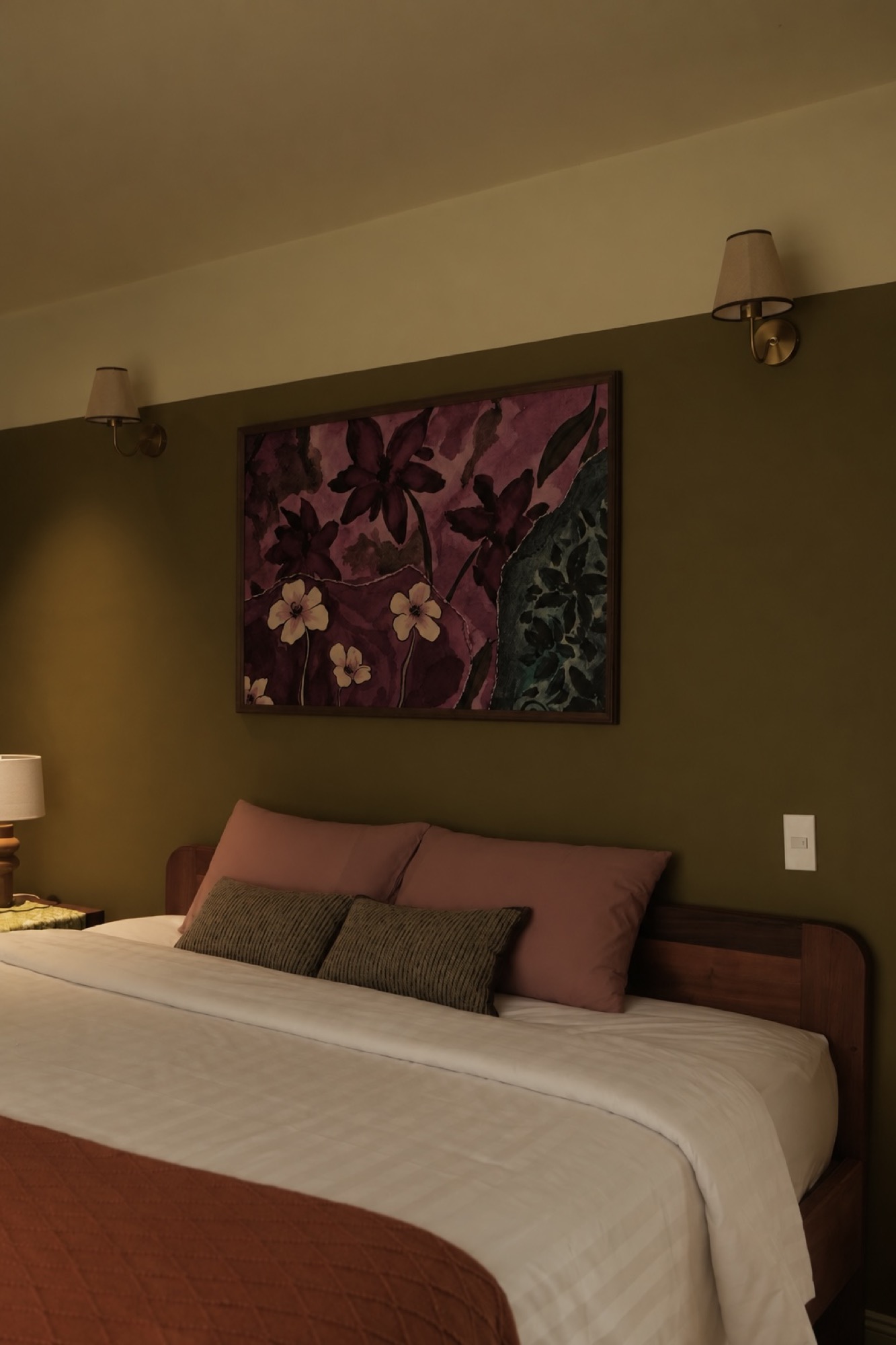 Portrait view of SERA's king bed beneath floral artwork